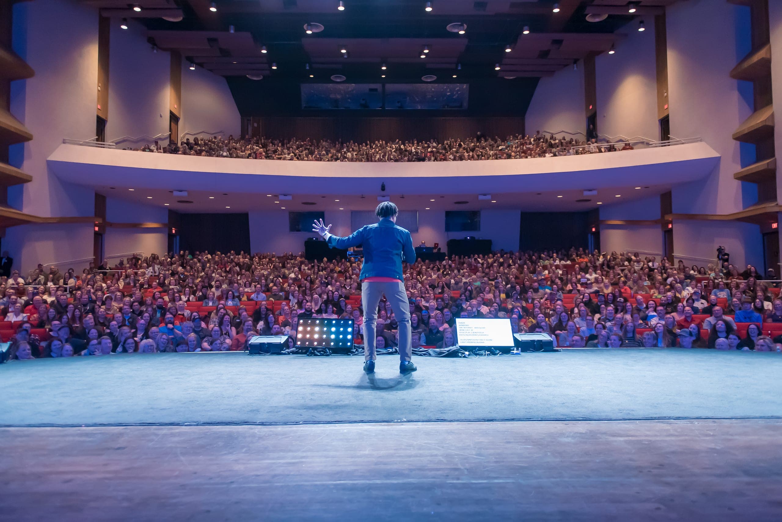 Antonio Neves on stage in a full theater, speaking to the audience